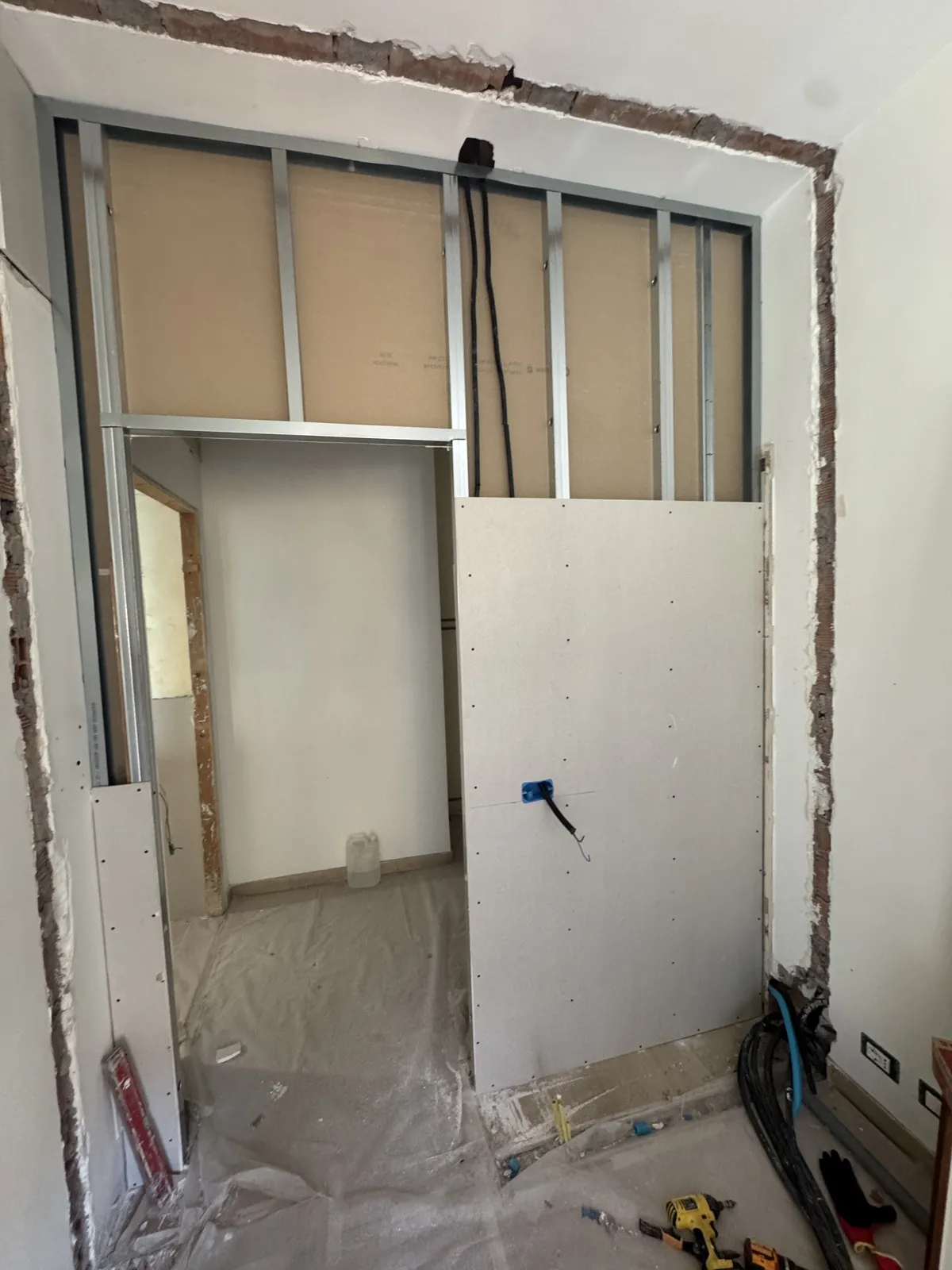 Nuovo tramezzo in cartongesso con il vano porta, durante i lavori in un appartamento a Roma